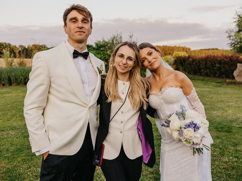 Panna młoda i pan młody pozujący na zewnątrz ze swoją wedding plannerką Karoliną Chorzępą z KC Event