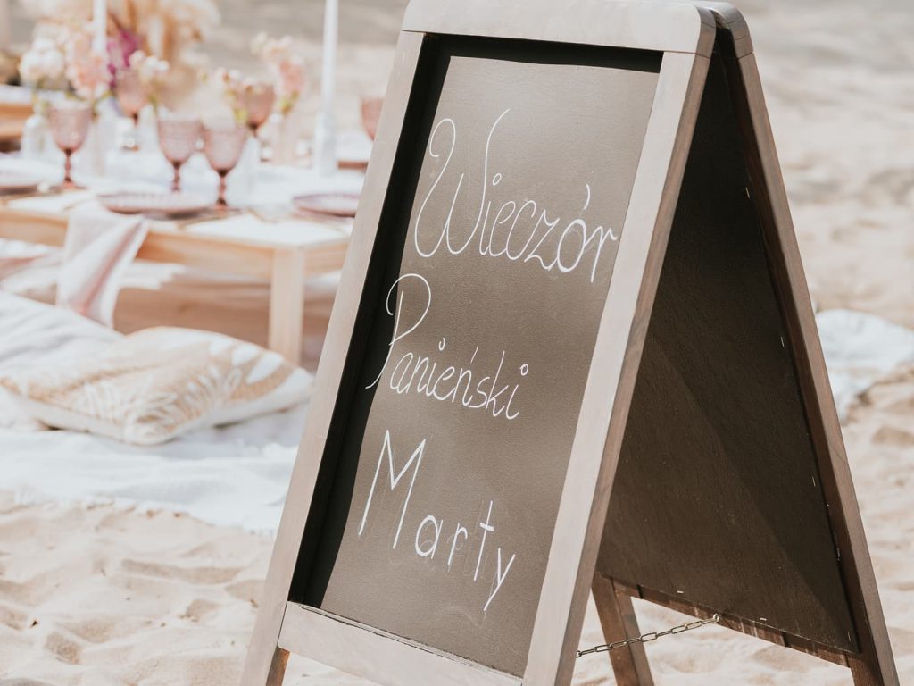 Znak na wieczór panieński na plaży z aranżacją piknikową przygotowana przez event plannerkę