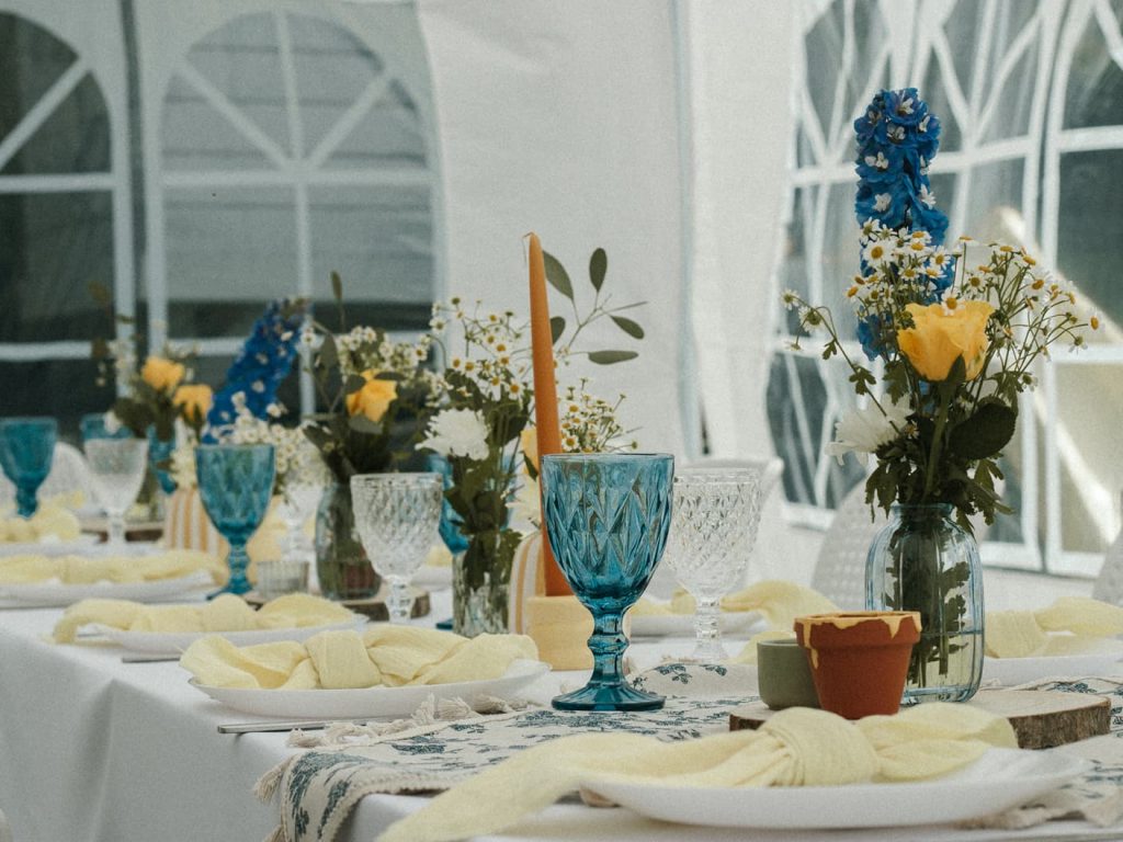 Elegancka aranżacja stołu z kwiatami i niebieskimi kieliszkami