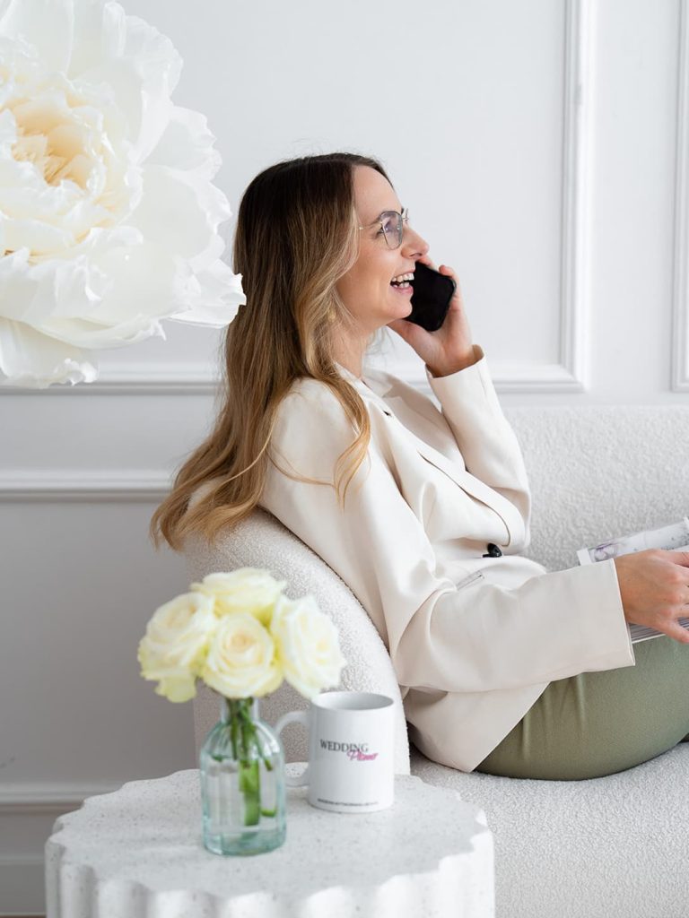 Uśmiechnięta event i wedding plannerka rozmawiająca przez telefon w jasnym biurze