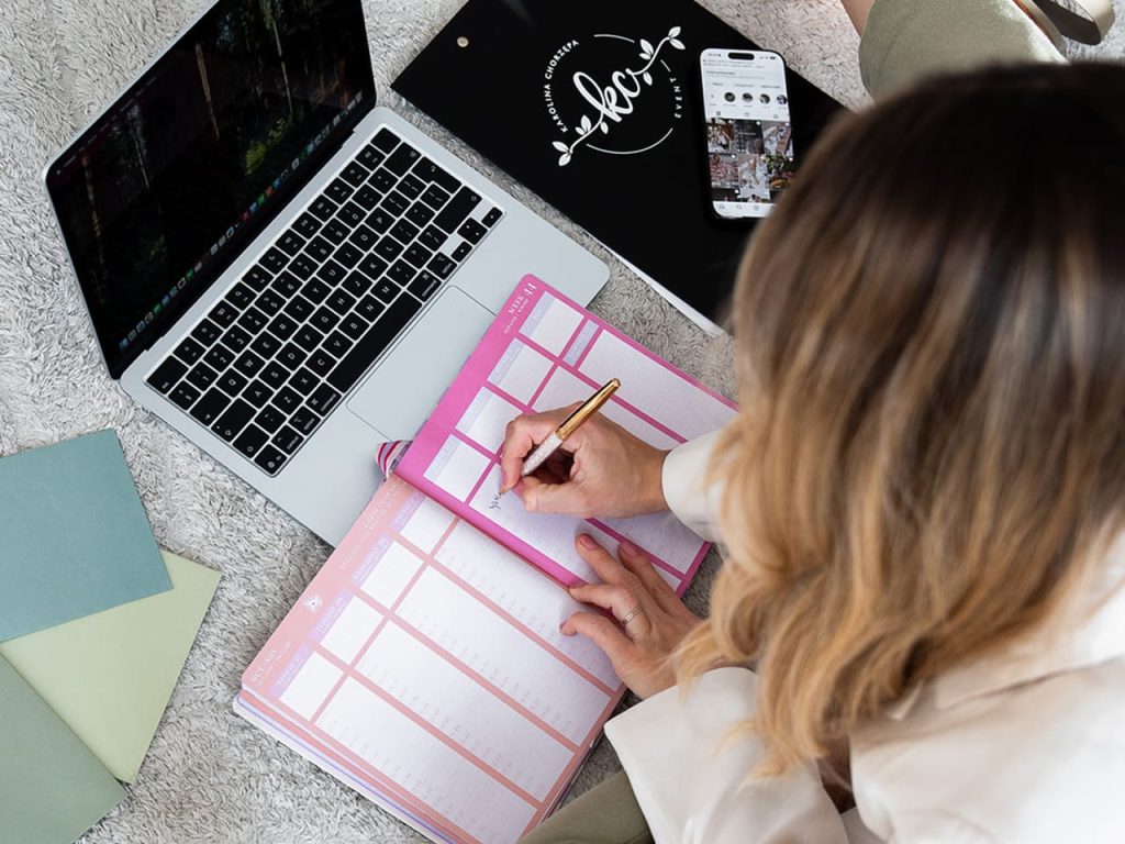 Event i Wedding Plannerka planująca harmonogram/plan zajęć przy użyciu laptopa i notatnika
